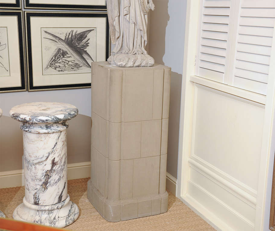 3rd quarter 20th century pair of Italian inspired neoclassical stone pedestals with stepped incising and rounded corners above a carved stepped base. Attributed to Michael Taylor.